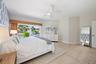 Large sliding glass door featuring integrated bamboo-finish valance, wood-finish flooring, and white multi-blade ceiling fan with light fixture