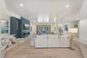 Living area featuring a shiplap ceiling, wood-finish flooring, a tiered floor design, a built-in linear fireplace, and an accent wall