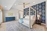 Vaulted ceilings with recessed lighting, patterned accent wallpaper, and a wood-finish ceiling fan