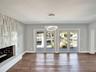 Living area featuring wood-finish flooring, a contemporary circular pendant light fixture, and dual sets of glass-paned doors