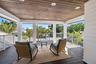 Covered balcony featuring wood-finish ceiling planks, recessed lighting, white railing, and dark composite decking