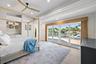 Recessed lighting, wood-finish flooring, built-in recessed shelving, ceiling fan with wood-finish blades, and expansive sliding glass doors opening to