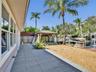 Rear outdoor area featuring a stone-tile patio, a gravel landscape, a wooden pergola, and a private dock