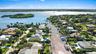 Aerial perspective of a waterfront residential area featuring deep-water canal access, private boat docks, and direct access to open water