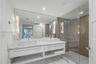 Floating vanity with dual rectangular vessel sinks, expansive wall-to-wall mirror, glass-enclosed shower with mosaic wall tiling, and stone flooring