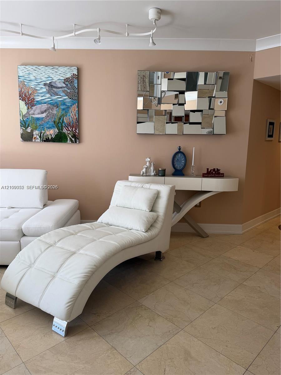 Large-format neutral tile flooring and multi-directional track lighting fixture