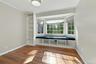 Front bedroom with bay window with seating and built-in bookshelves.