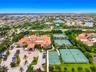 Mediterranean-style estate featuring a multi-story clubhouse, circular motor court with central fountain, multiple tennis courts, and a basketball cou