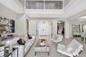 Double-height foyer featuring a mezzanine overlook, polished tile flooring, arched entryways, and double front doors
