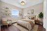 Room featuring wood-finish flooring, three built-in wall-mounted shelves, a single-hung window, and a drum-style ceiling light fixture