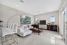 Open-concept living space featuring high ceilings, neutral wall tones, large-format tile flooring, recessed lighting, and sliding glass doors