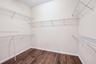 Walk-in closet featuring wood-finish flooring and tiered white wire shelving