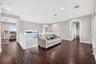 Open loft area featuring wood-finish flooring, recessed lighting, and a white balustrade railing overlooking the water