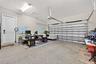 Finished garage featuring a concrete floor, automated overhead door, ceiling-mounted light fixture, and an interior access door