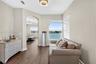 Wood-finish flooring, arched entryway, large window with water scenery, and decorative drum-style ceiling lighting