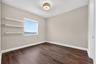 Wood-finish flooring, neutral wall tones, built-in shelving, energy-efficient window, and decorative semi-flush mount lighting
