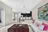Kitchen featuring dark cabinetry, recessed lighting, and a stone-tiled breakfast bar, complemented by glossy tile flooring and an arched entryway