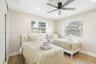 Neutral-toned interior featuring wood-finish tile flooring, recessed ceiling lighting, a matte black multi-blade ceiling fan, and horizontal window bl