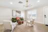 Living area featuring wood-finish flooring, a contemporary multi-light chandelier, crown molding, and plantation shutters