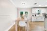 White cabinetry, wood-finish flooring, crown molding, and glass-paneled double doors featuring matte black hardware
