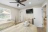 Wood-finish flooring, multi-blade ceiling fan with integrated lighting, recessed lighting, and horizontal slatted window blinds
