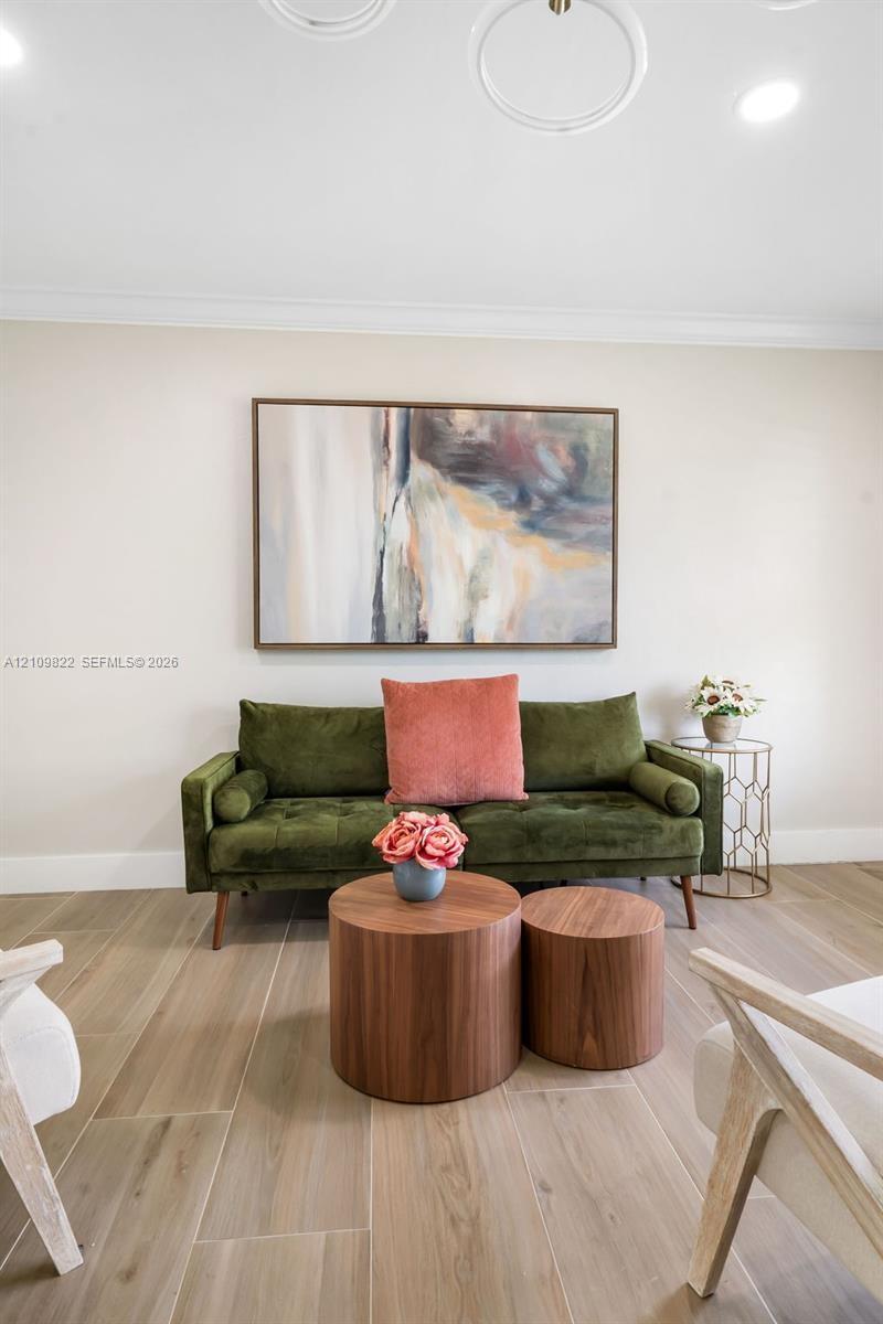 Wood-finish tile flooring, neutral wall palette, and recessed circular ceiling light fixtures