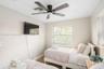 Neutral-toned interior featuring recessed lighting, a modern ceiling fan with wood-finish blades, and windows equipped with horizontal blinds