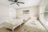 Neutral-toned interior featuring wood-finish flooring, a multi-blade ceiling fan, recessed lighting, and dual-window installations with horizontal bli