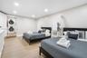 Neutral-toned room featuring wood-finish flooring, recessed lighting, and a laundry closet equipped with a stacked washer and dryer