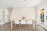 Neutral-toned interior featuring wood-finish flooring, crown molding, and a full-light glass panel door
