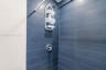 Shower surround featuring large-format dark blue rectangular wall tiles and a polished chrome single-handle mixing valve