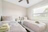 Neutral interior with horizontal window blinds and a ceiling fan