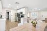 Kitchen featuring white cabinetry, stainless steel appliances, wood-finish flooring, recessed lighting, and a multi-light chandelier