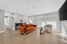 Interior living space featuring wood-finish flooring, recessed lighting, and large windows with horizontal blinds