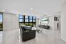 Large-format tile flooring, expansive floor-to-ceiling windows with black mullions, and integrated recessed ceiling lighting