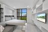 Covered balcony featuring large-format tile flooring and a glass-paneled railing