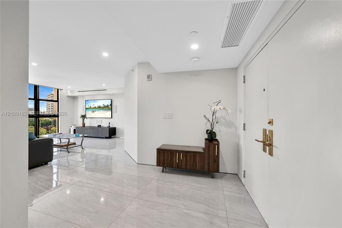 Polished stone-finish flooring, floor-to-ceiling windows, and recessed lighting