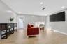 Spacious interior featuring neutral wall tones, recessed lighting, wood-finish tile flooring, and a glass-paneled exterior door