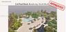 Waterfront pool deck featuring an expansive sun terrace, multiple water features, manicured landscaping with mature palms, and covered pavilion struct