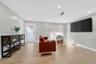 Neutral-toned interior featuring wood-finish flooring, recessed lighting, and a single-pane glass door with white trim
