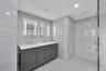 Floor-to-ceiling sliding glass doors, large private balcony with metal railing, polished stone-finish flooring, and expansive window lines