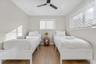 Neutral-toned walls paired with wood-finish flooring, featuring recessed ceiling lighting, a matte black ceiling fan, and horizontal window blinds