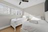 Wood-finish flooring, recessed lighting, ceiling fan with integrated light, and large horizontal window with fitted blinds