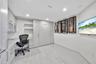 Contemporary kitchen featuring flat-panel cabinetry, a stone-surfaced kitchen island, integrated appliances, and large-format tile flooring