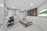 Contemporary kitchen featuring flat-panel cabinetry, a spacious island with a solid-surface countertop, integrated wine refrigeration, and large-forma