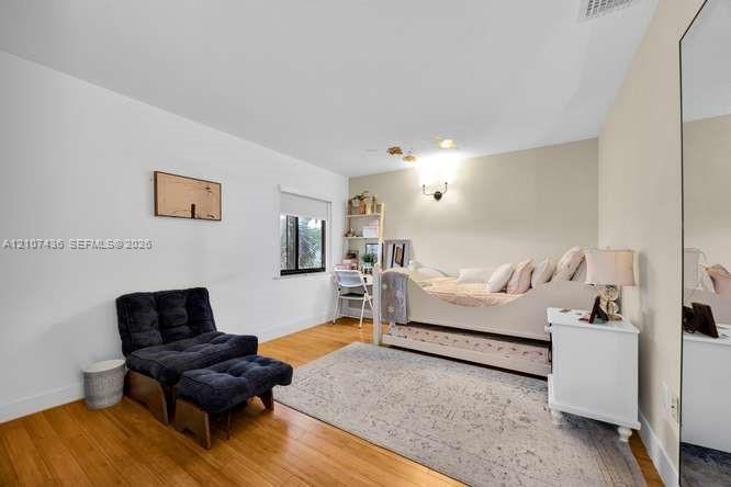 Neutral wall tones, wood-finish flooring, and a large wall-mounted mirror