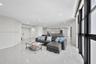 Open-concept floor plan featuring large-format polished tile flooring, floor-to-ceiling windows with dark framing, recessed lighting, and built-in min