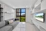 Covered balcony featuring large-format tile flooring and a glass-paneled railing