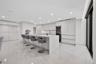 Open kitchen featuring flat-panel cabinetry, a central island with a solid-surface countertop, built-in wine refrigeration, and polished stone-finish 