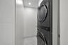 Built-in white cabinetry, integrated desk, light-tone tile flooring, floor-to-ceiling windows, and wall-mounted shelving